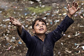 An Afghan refugee child chases bubbles released by other children while playing on the outskirts of Islamabad, Pakistan, on Aug. 8, 2014.