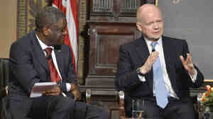 Dr. Denis Mukwege (left) listens as Britain's Foreign Secretary William Hague speaks after the two men were presented Georgetown University's annual Hillary Rodham Clinton Award for Advancing Women in Peace and Security, at Georgetown University in Washington, in February.