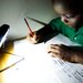 A schoolboy in Zambia's Chadiza district  does his homework with the help of a solar lantern that can provide up to eight hours of light on a single day's charge. Crowdfunding helped finance a project to distribute lights to people living off the grid there.