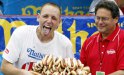 Brooklyn, UNITED STATES: Joey Chestnut (L) of San Jose, California celebrates winning the annual International July Fourth Hot Dog Eating Contest by holding a plate of 66 hot dogs and buns with an unidentifed official, 04 July 2007, at the original Nathan?s Famous restaurant in the Coney Island section of Brooklyn, NY. Chestnut won by eating 66 hot dogs in 12 minutes, a world record, beating defending and six-time champion Takeru Kobayashi of Nagano, Japan. The initial count was tied at 63 after the 12 minutes, but judges awarded Chestnut 3 more hot dogs after counting their plates.