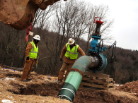 Employees of an oil and gas company work on a natural gas valve at a hydraulic fracturing site. (credit: Spencer Platt/Getty Images)