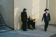 Elimelech Ehrlich (seated), a beggar who travels each year from Jerusalem, talking with students outside Beth Medrash Govoha.