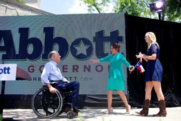 Greg Abbott greets his family onstage Sunday