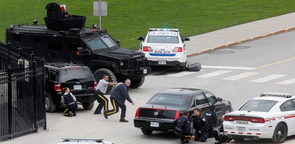 PHOTO: Police officers take cover near Parliament Hilll following a shooting incident in Ottawa, Oct. 22, 2014. 