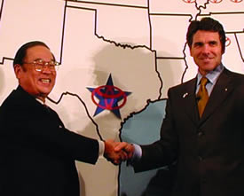 Rick Perry shakes hands with a Toyota executive in 2009