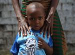 PAYNESVILLE, LIBERIA - OCTOBER 16:  Ebola survivor James Mulbah, 2, stands with his mother, Tamah Mulbah, 28, who also recovered from Ebola in the low-risk section of the Doctors Without Borders (MSF), Ebola treatment center after survivors' meeting on October 16, 2014 in Paynesville, Liberia. The virus has a 70 percent mortality rate, according to the World Health Organization, but leaves survivors immune to the strain that sickened them.