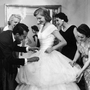 Baroness Aino Bodisco (far right) looks on as Beatrice Lodge is fitted in a debutante dress by fashion designer Oscar de la Renta in 1956.
