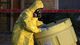 A hazmat worker moves a barrel while finishing up cleaning