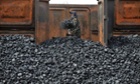 A worker unloads coal at a storage site along a railway station in Shenyang, Liaoning province, in this file picture taken April 13, 2010.