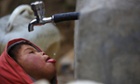 A boy drinks water from a public tap in Solukhumbu District