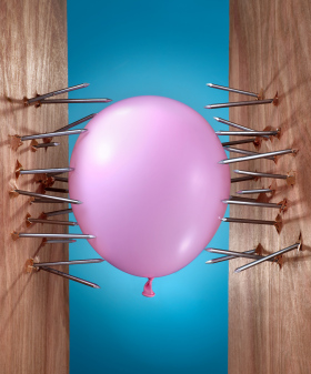 Pink balloon between two sets of nails