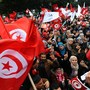 Tunisians wave their national flag and shout slogans on Tuesday in the capital, Tunis, as they attend a rally marking the third anniversary of the uprising that ousted longtime dictator Zine El Abidine Ben Ali.