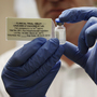 Adrian Hill, director of the Jenner Institute and chief investigator of the trials with an Ebola vaccine his organization developed, holds a vial of the vaccine.