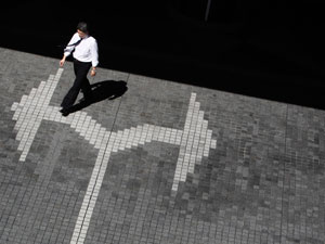 A man walks on a road marking at a business district in Tokyo Caption|REUTERS/Kim Kyung-Hoon