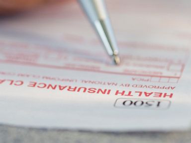 PHOTO: A man filling out a health insurance claim form is pictured in this stock image. 