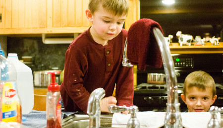 Christine Pepper's sons watch as dirty water drips from the faucet.  photo: jbpribanic