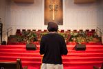 A woman, who asked not to be identified because she fears for her safety, stands near the pulpit at the end of service at First Baptist Church on Sunday, Sept. 14, 2014, in El Paso. The woman fled Boko Haram in Nigeria and is now seeking asylum.