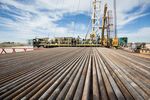 Pipes used for fracking are shown in front of a Fasken OIl and Ranch drilling rig outside of Midland on Oct. 8, 2013.