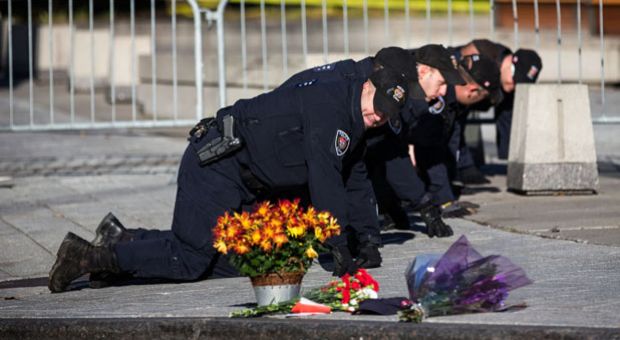Members of the Ottawa Police sweep the area in front of the National War Memorial one day after a lone gunman killed Cpl. Nathan Cirillo of the Canadian Army Reserves, who was standing guard at the memorial, on October 23, 2014 in Ottawa, Canada. After killing Cirillo the gunman stormed the main parliament building, terrorizing the public and politicians, before he was shot dead. 