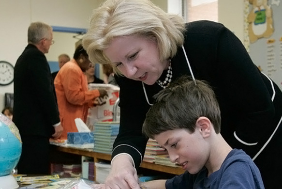 Senator Nelson, a former teacher, takes a moment to coach a youngster in class.