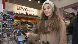 A customer makes a purchase using Apple Pay on her iPhone 6 at a Walgreens store in Times Square last Monday. The mobile payment service has now been blocked by CVS and Rite Aid.
