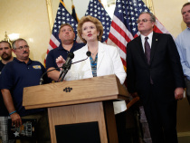 U.S. Sen. Debbie Stabenow (C) (D-MI), joined by workers from the UAW and the United Steelworkers, speaks at a press conference about the "Bring Jobs Home Act" as U.S. Sen. Mark Pryor (2nd R) (D-AR) looks on at the U.S. Capitol July 22, 2014 in Washington, DC.  (Credit: Win McNamee/Getty Images)
