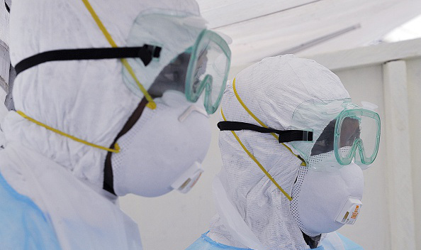 Kenyan medical workers from the Infection Prevention and Control unit wearing full protective equipment are pictured as they show on October 28, 2014, how to handle an infected Ebola patient on a portable negative pressure bed at the Kenyatta national hospital in Nairobi. (SIMON MAINA/AFP/Getty Images)