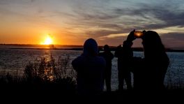 Spectators in Chincoteague, Va. watch the fireball from the explosion of the unmanned Orbital Sciences Corp.'s Antares rocket and Cygnus cargo capsule seconds after liftoff from Wallops Island, Va. on Tuesday, Oct. 28, 2014. No injuries were reported following the first catastrophic launch in NASA's commercial spaceflight effort.