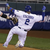 The San Francisco Giants' Brandon Belt can't reach the Kansas City Royals' Alcides Escobar as he slides safely to first base on an infield single Tuesday night during the second inning of Game 6 of baseball's World Series in Kansas City, Mo. Escobar eventually would score the Royals' fourth run.