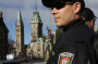 Ottawa police officers, with Parliament Hill in the background, guard the area around the National War Memorial in downtown Ottawa on Thursday. (Reuters/Landov)