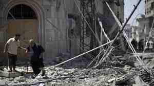 Palestinian men walk amidst debris following an Israeli military strike in Gaza city, on July 23, 2014.