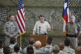 Texas Governor Rick Perry, flaned by Adjutant General John Nichols, l, and DPS Director Steve McCraw, talks to National Guard troops at Camp Swift on August 13, 2014.