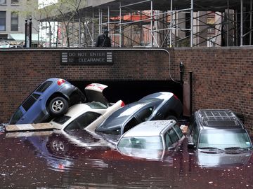 Cars piled on top of each other at the entrance to a garage on South Willliam Street in Lower Manhattan October 31, 2012 in New York as the city begins to clean up after Hurricane Sandy.