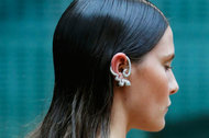 A model wears a silver serpentine ear cuff at Julien Macdonald.