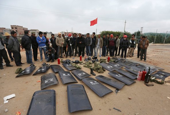 Villagers in Fuyou, Jinning County, displaying police shields and other equipment they confiscated after a clash with construction workers on Oct. 14.