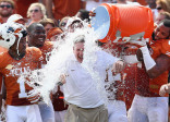 DALLAS, TX - OCTOBER 12:  Head coach Mack Brown of the Texas Longhorns has a cooler of ice water dumped on him by his team after the Longhorns beat the Oklahoma Sooners 36-20 at the Cotton Bowl on October 12, 2013 in Dallas, Texas.  (Photo by Tom Pennington/Getty Images)