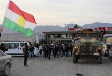 A man waves a Kurdistan flag as a Turkish military truck escorts a convoy of peshmerga vehicles at Habur border gate, which separates Turkey from Iraq, near the town of Silopi in southeastern Turkey, October 29, 2014. REUTERS/Kadir Baris