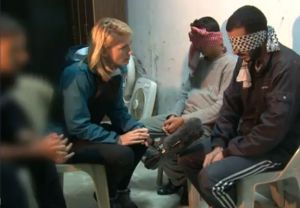 In a screenshot from her CBS News report, Holly Williams is pictured speaking with  two prisoners in Syria, who are accused of being ISIS terrorists. (CBS News screenshot)