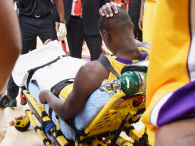 Julius Randle of the Los Angeles Lakers holds his head as he is wheeled away in a stretcher, October 28, 2014 against the Houston Rockets at Staples Center in Los Angeles, California. The rookie forward Randle, 19, reportedly suffered a broken leg during his NBA debut against the Rockets.  (Photo: ROBYN BECK/AFP/Getty Images)