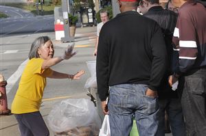  "Wait, I've got more," says a-Mee Li, who works for a group she calls "Peace," as she hands out surplus baked goods to people in need on the Boulevard of the Allies near the corner with Stanwix Street. The bread and pastry were donated by local establishments.
