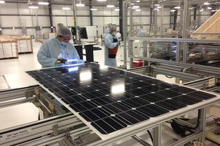 A worker at Mission Solar in San Antonio inspects the protective coating of a fully assembled solar panel for bubbles that could hinder efficiency. The company runs Texas' biggest solar panel manufacturing plant.
