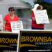 Protesters in Olathe, Kan., stand outside a campaign rally for Gov. Sam Brownback in July. 