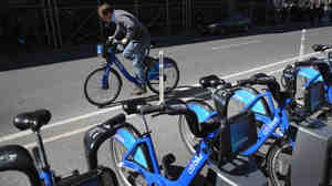 A Citi Bike user pedals off from a bicycle station. The company that owns the service in New York and other cities has been sold, after suffering problems tied to its supply chain and the weather.