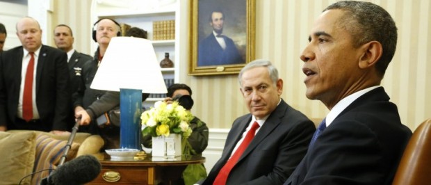 Netanyahu listens to remarks by Obama as they sit down to meet in the Oval Office of the White House in Washington