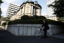 A man cycles past the Bank of Japan building in Tokyo October 31, 2013.  REUTERS/Yuya Shino