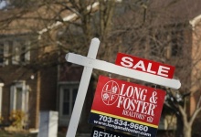 A home for sale sign hangs in front of a house in Oakton, Virginia, March 27, 2014. REUTERS/Larry Downing