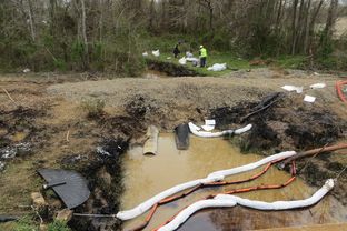 Workers mop up tar sands oil from a creek in the wake of Exxon Mobil's Pegasus pipeline spill, Mayflower, Arkansas.