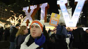 Super Bowl volunteer Ben Schreiber distributes fan guides for Super Bowl XLVI festivities in 2012.