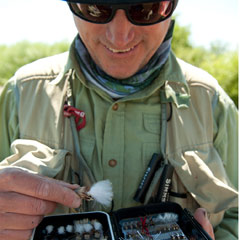 Photo of angler selecting a fly from box of flies.