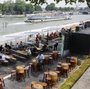Parisians and tourists sit at a cafe along the Seine River. The mayor of Paris recently closed down a major highway along the river to open it up for pedestrians.
